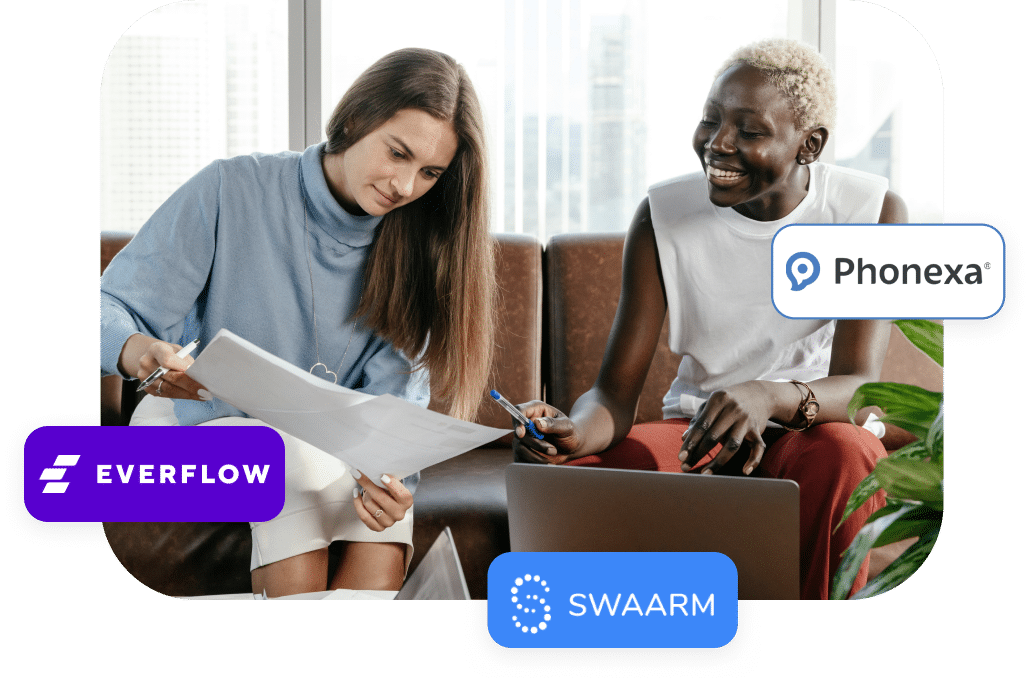Two women work together at a table with documents and a laptop. Company logos of Everflow, Phonexa, and Swaarm are displayed in the image.