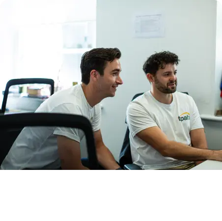 Two career-focused men sitting at a desk in an office.