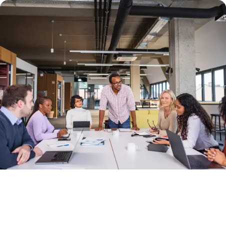 A group of people sitting around a table in an office for a career update meeting.
